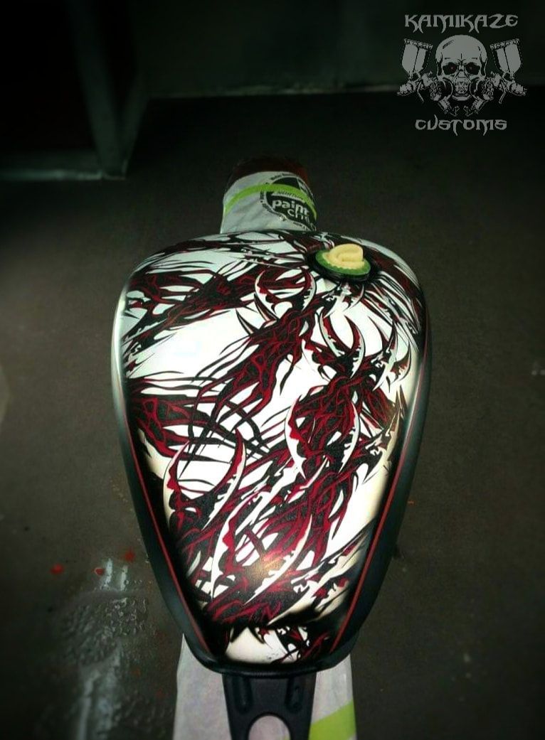 A motorcycle tank with a carnage design on it.