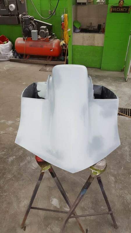 A white object is sitting on top of a metal stand in a garage.
