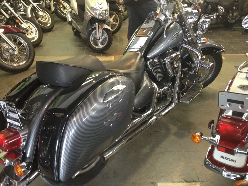 A suzuki motorcycle is parked in a showroom