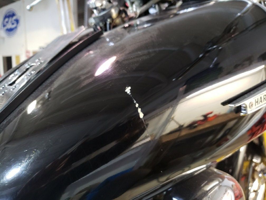 A close up of a black motorcycle 's fuel tank