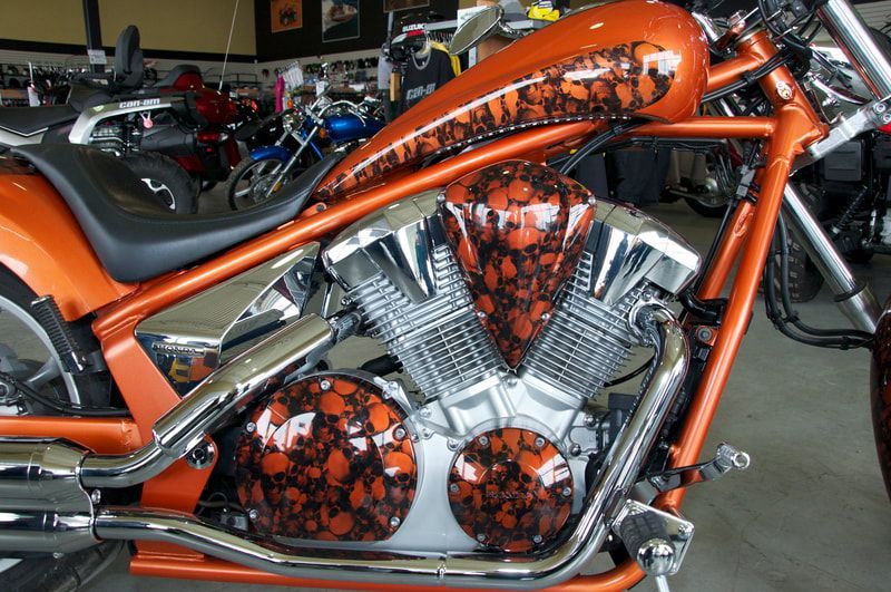 An orange motorcycle with skulls painted on it