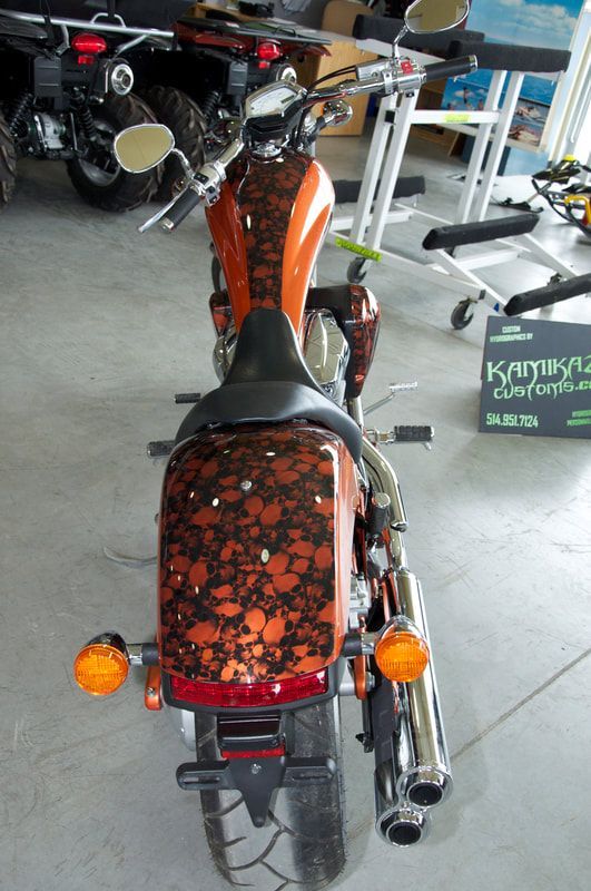 A motorcycle is parked in a garage next to a sign that says kumpu