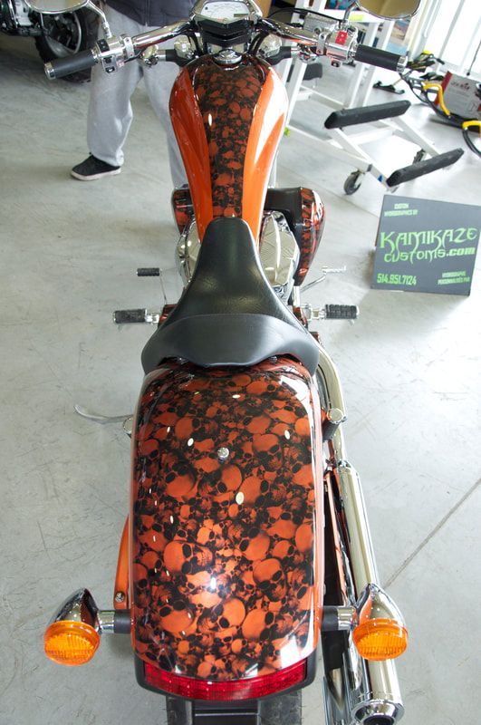 An orange and black motorcycle is parked in a garage