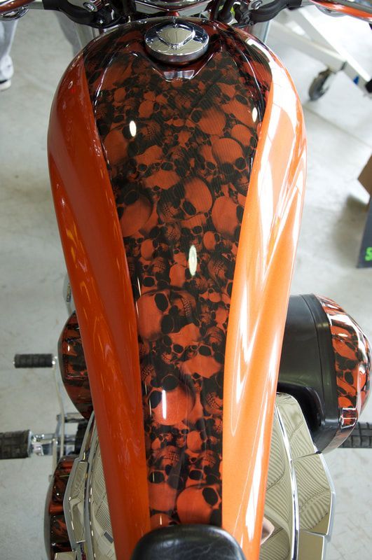 An orange motorcycle with skulls painted on it