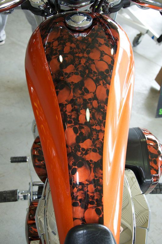 An orange motorcycle with skulls painted on it