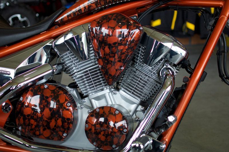 A close up of a motorcycle engine with skulls painted on it