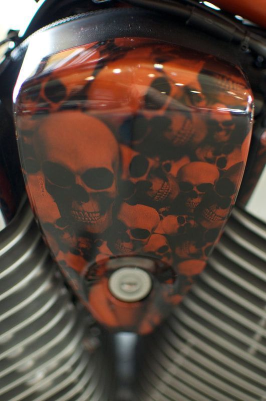A close up of a motorcycle with skulls painted on it.