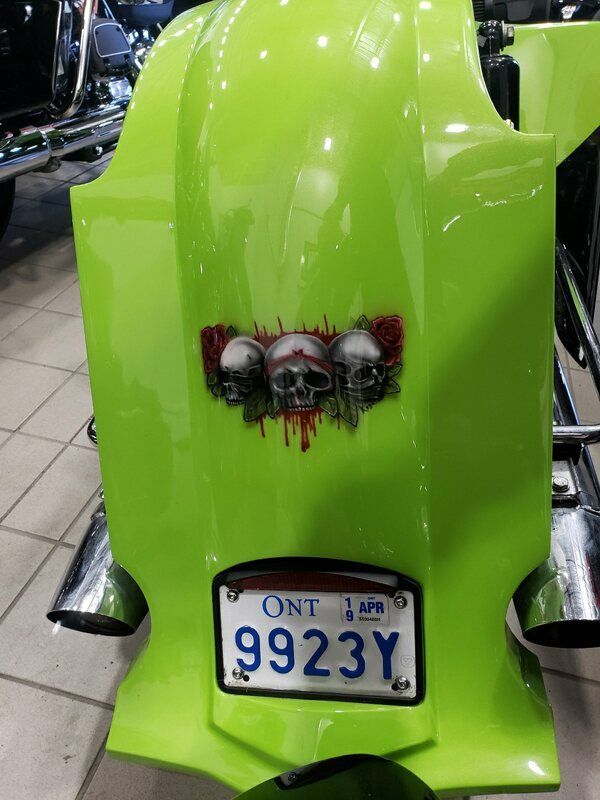 A green motorcycle with ontario license plate 9923y