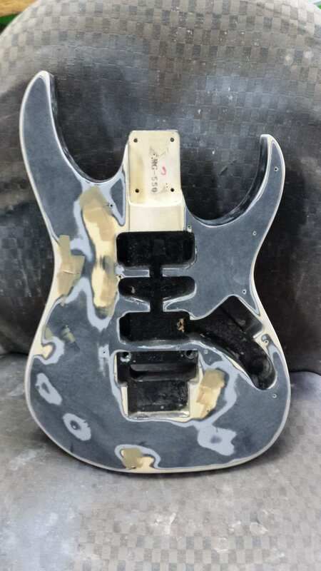 A guitar body is sitting on top of a rock.