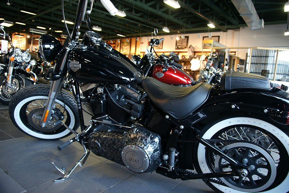 A black harley davidson motorcycle is parked in a showroom