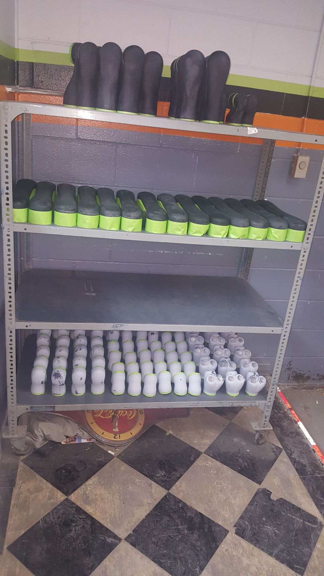 A shelf filled with lots of cups on a checkered floor.