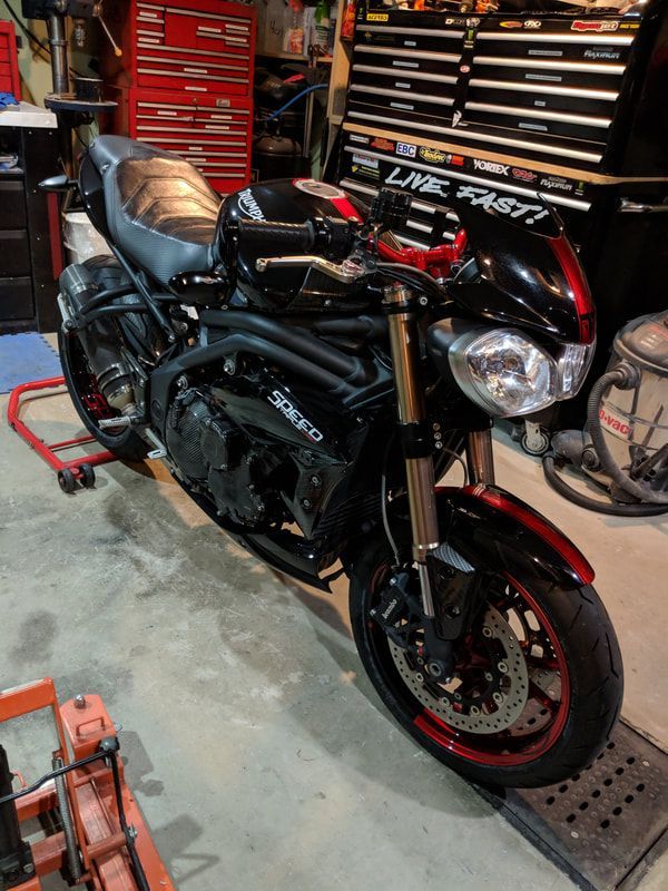 A black and red motorcycle is parked in a garage.