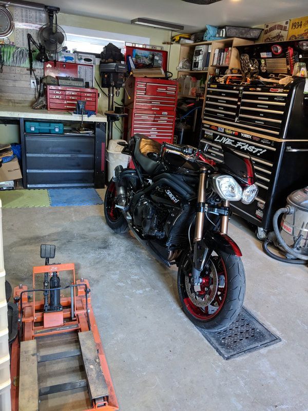 A black and red motorcycle is parked in a garage.