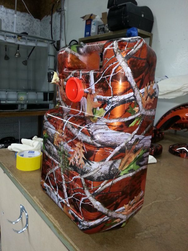 A camouflage container with a red cap sits on a table