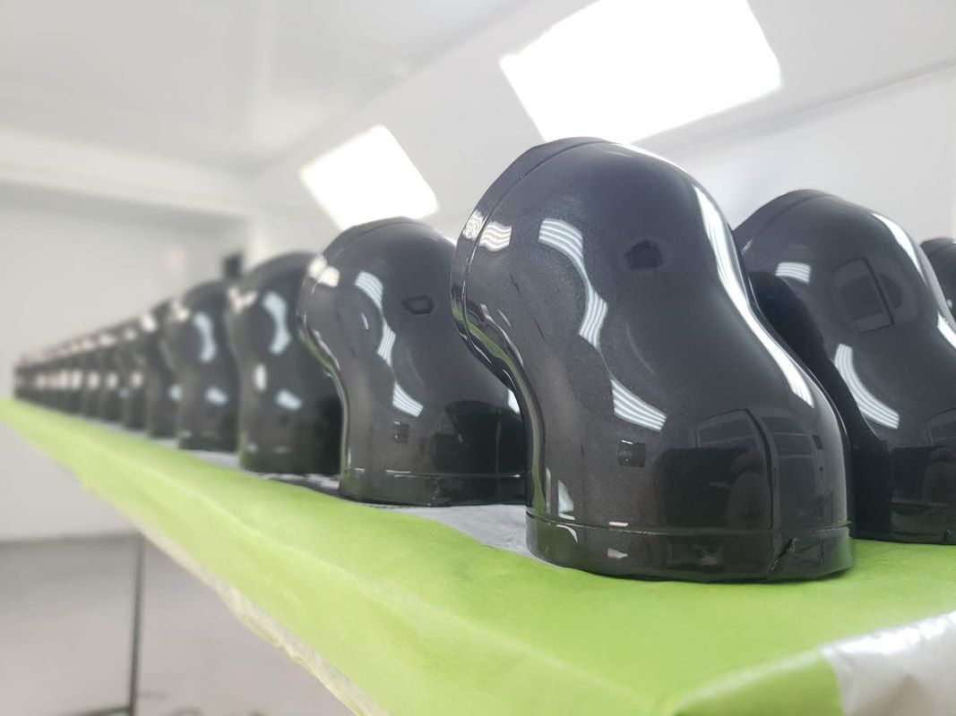 A row of black shoes sitting on top of a green table.