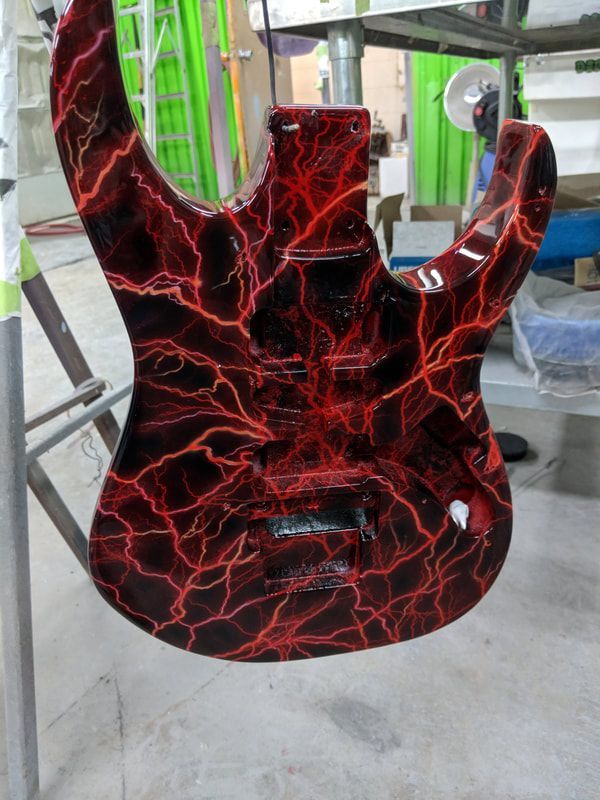 A guitar with a red lightning design on it