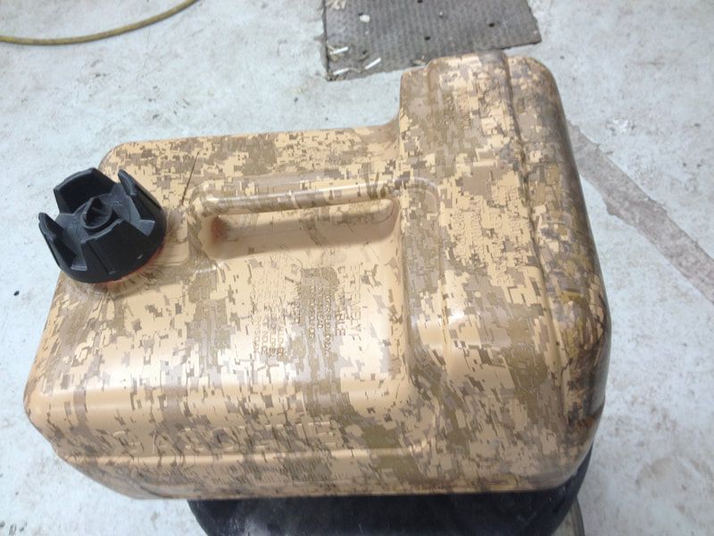 A brown container with a black cap sits on the ground