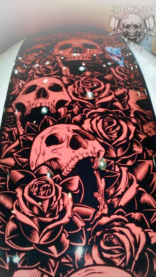 A skateboard with skulls and roses on it