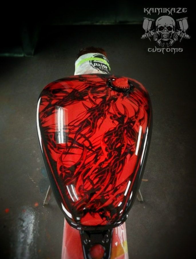 A red motorcycle tank with a skull on it