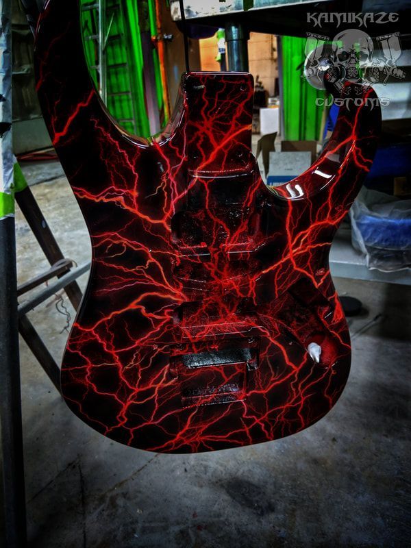 A guitar with a red lightning design on it
