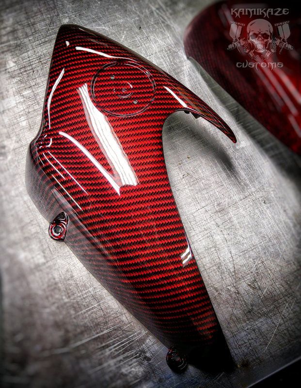 A close up of a red motorcycle fender on a metal surface.