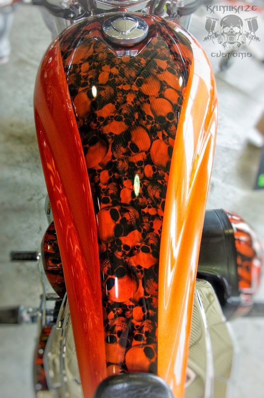 A close up of a motorcycle with skulls painted on it