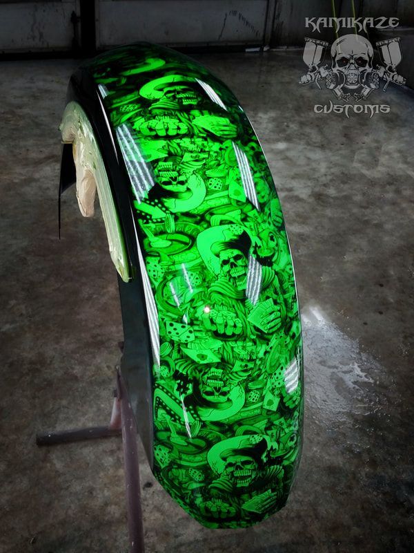 A green motorcycle wheel with skulls painted on it