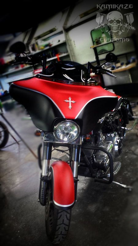 A red and black motorcycle with a cross on the front