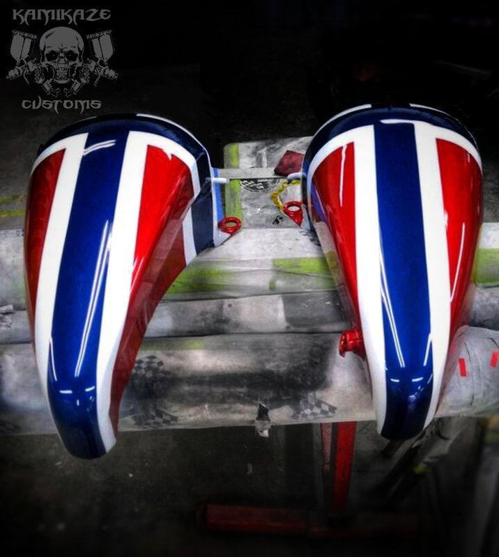 A pair of red white and blue motorcycle tanks