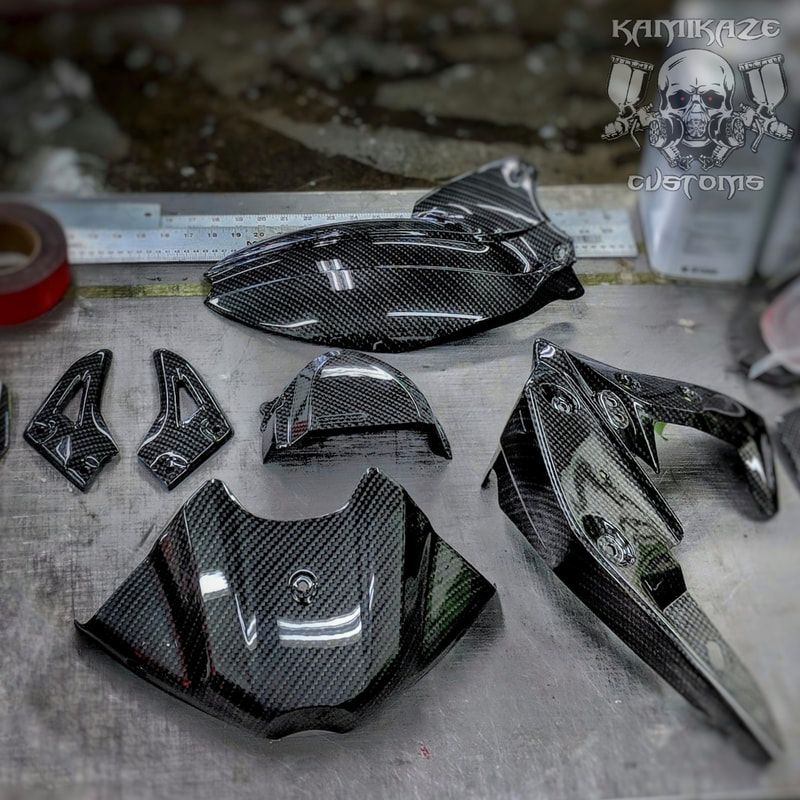 A bunch of carbon fiber parts are sitting on a table.