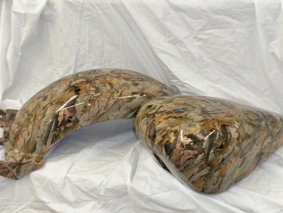 Two sculptures are sitting on a white cloth on a table.