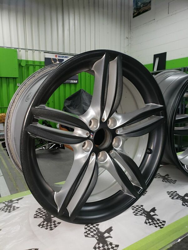 A close up of a black and silver wheel on a table