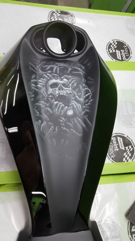 A black motorcycle tank with a skull on it