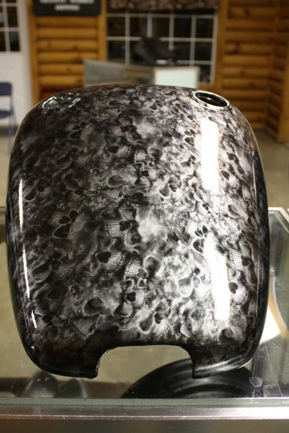 A black vase is sitting on top of a glass table.