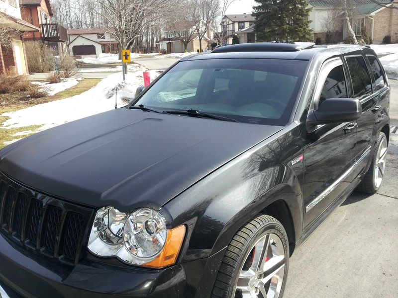 A black jeep is parked on the side of the road
