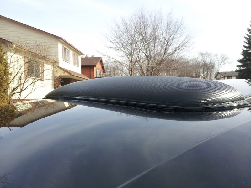 A black car is parked in front of a house