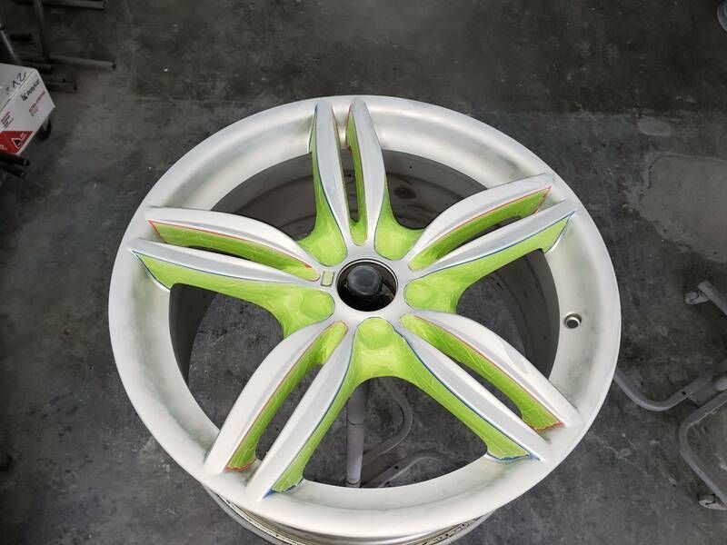 A white wheel with green spokes is sitting on a table
