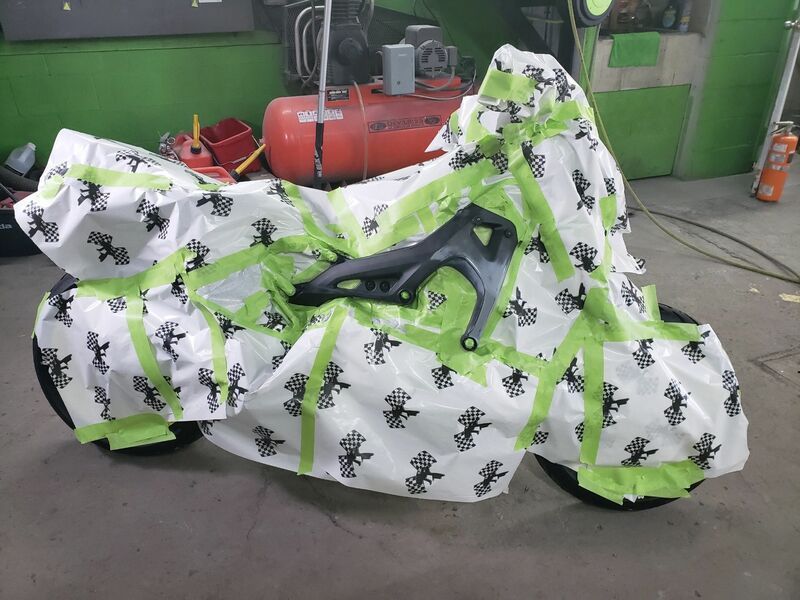 A motorcycle is wrapped in green and white tape