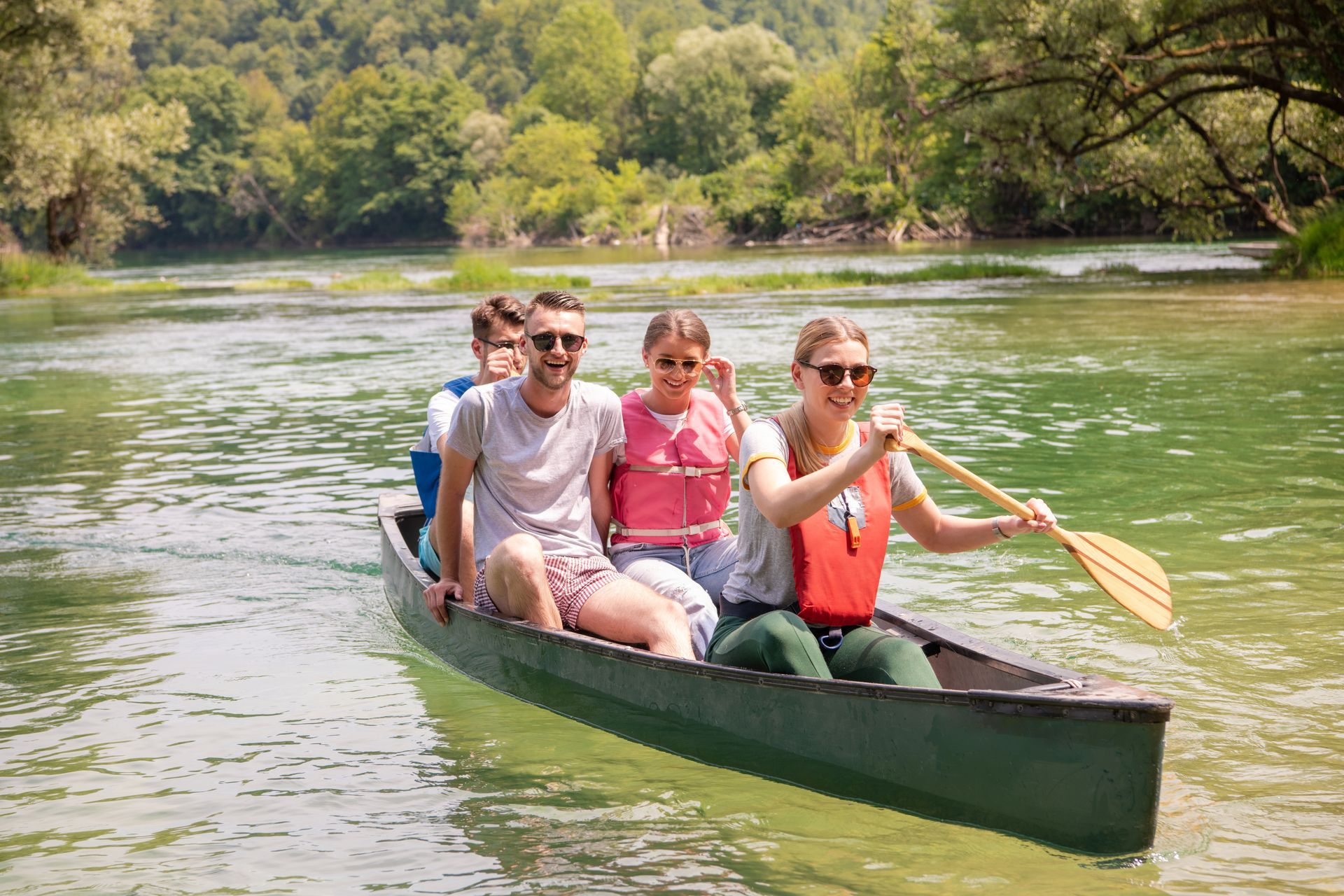 A family is paddling a canoe down a river.