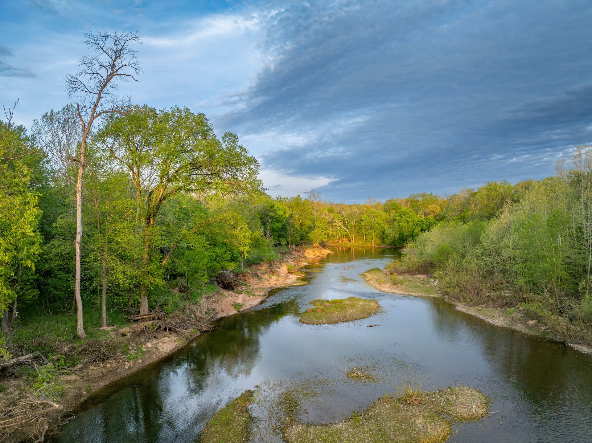 A river surrounded by trees on a cloudy day