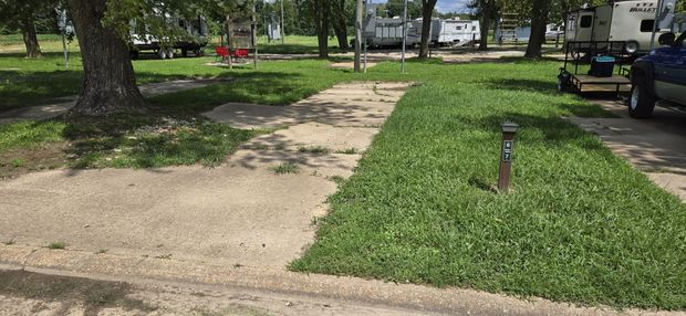 A lawn mower is cutting the grass in a park.