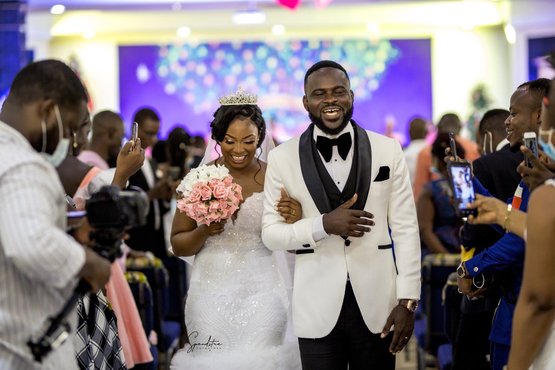 A bride and groom are walking down the aisle at their wedding.