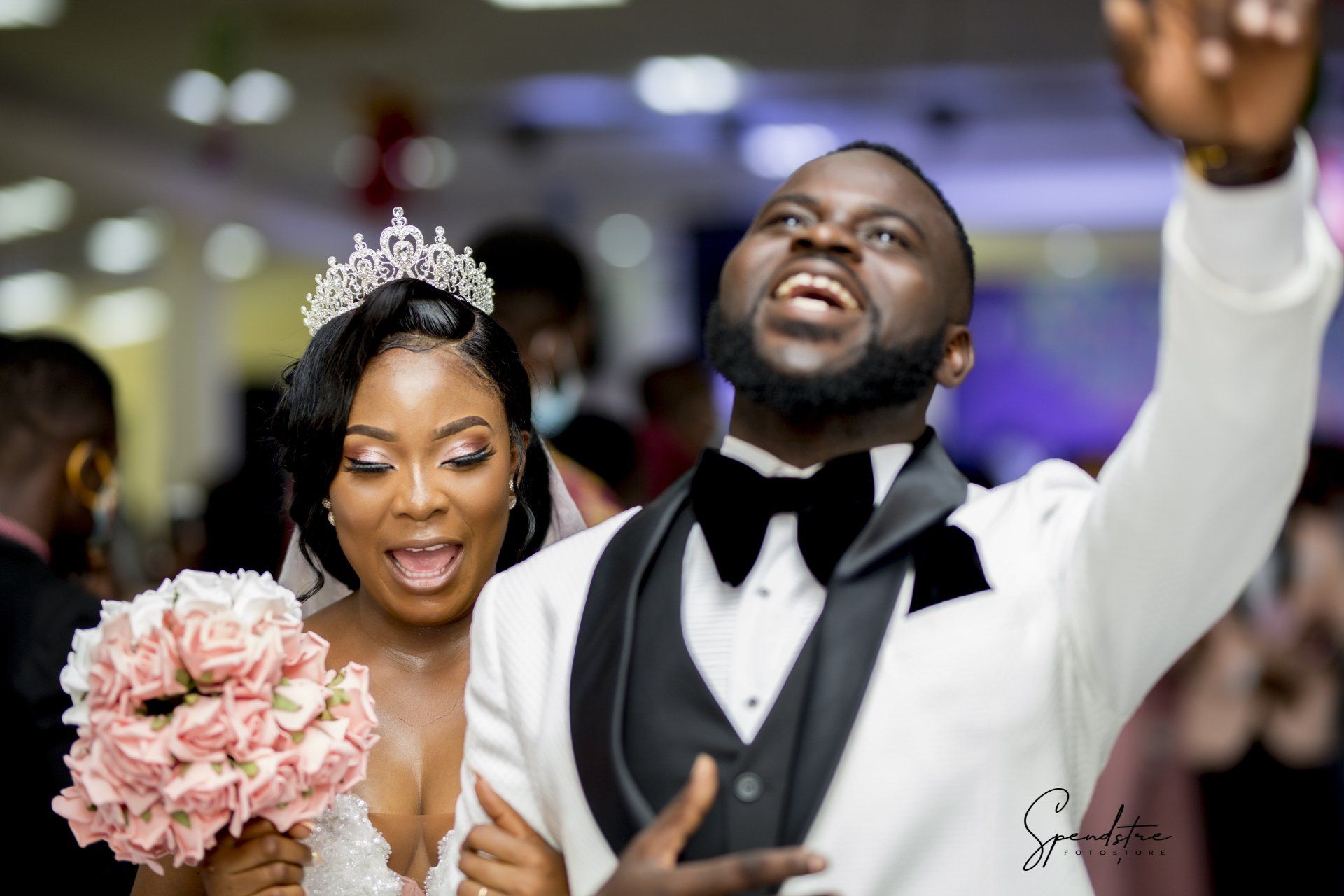 A bride and groom are posing for a picture at their wedding reception.