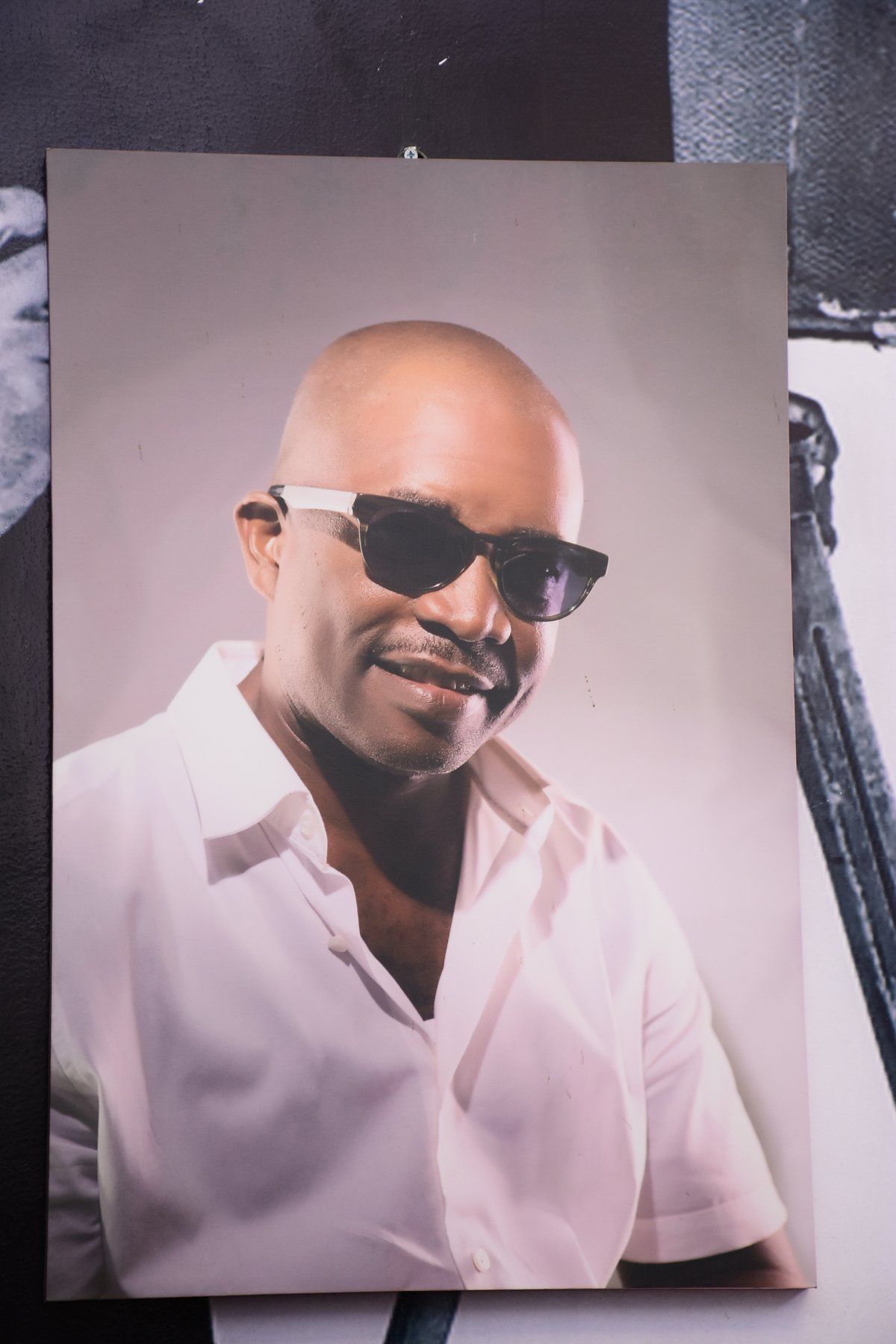A picture of a bald man wearing sunglasses and a white shirt