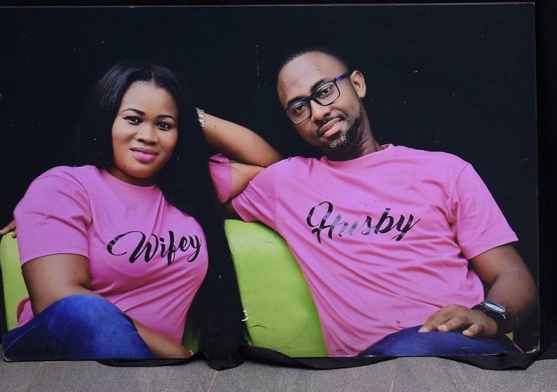 A man and woman wearing pink shirts that say wifey and husby
