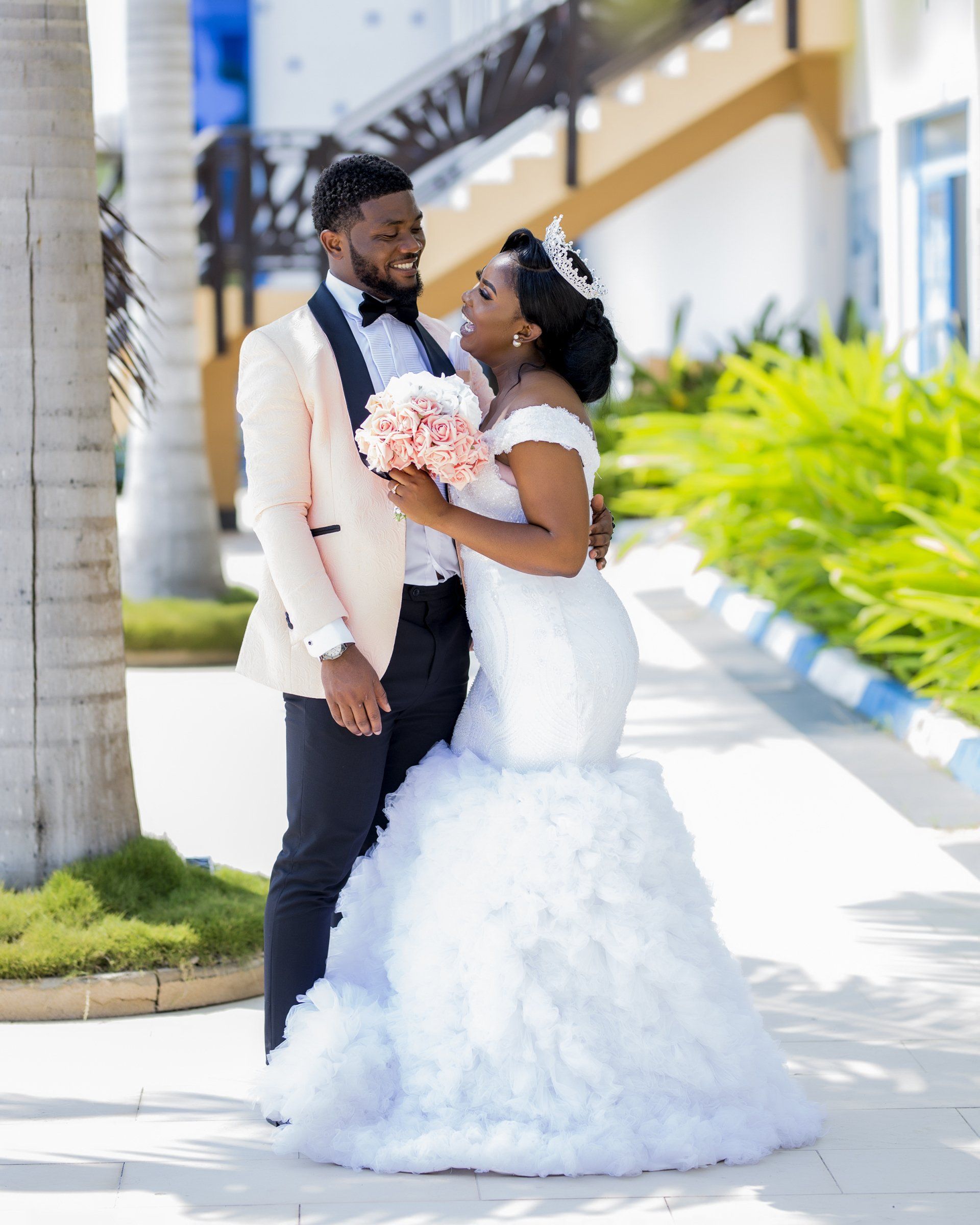 A bride and groom are posing for a picture on their wedding day