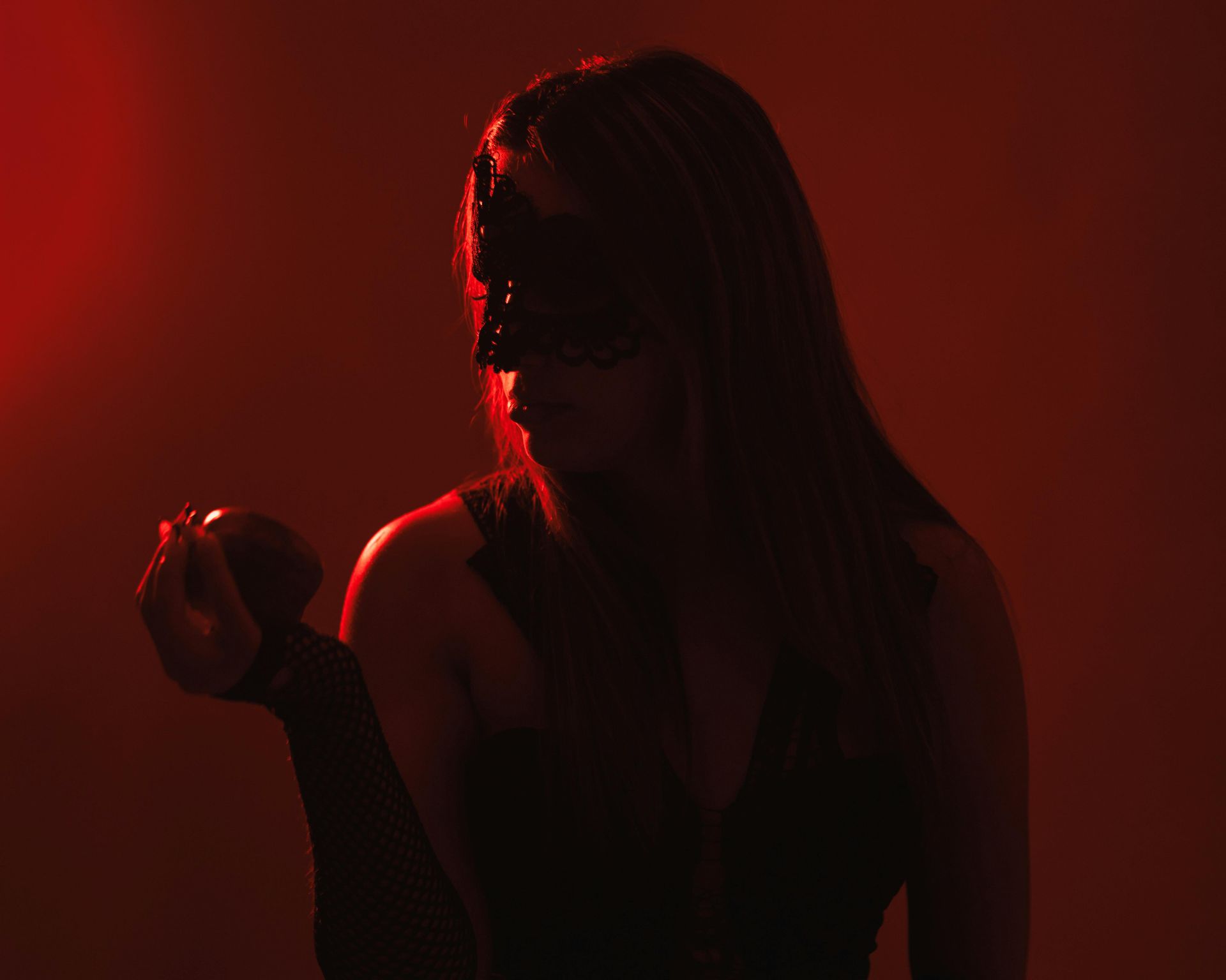 Woman looking at a apple red tones
