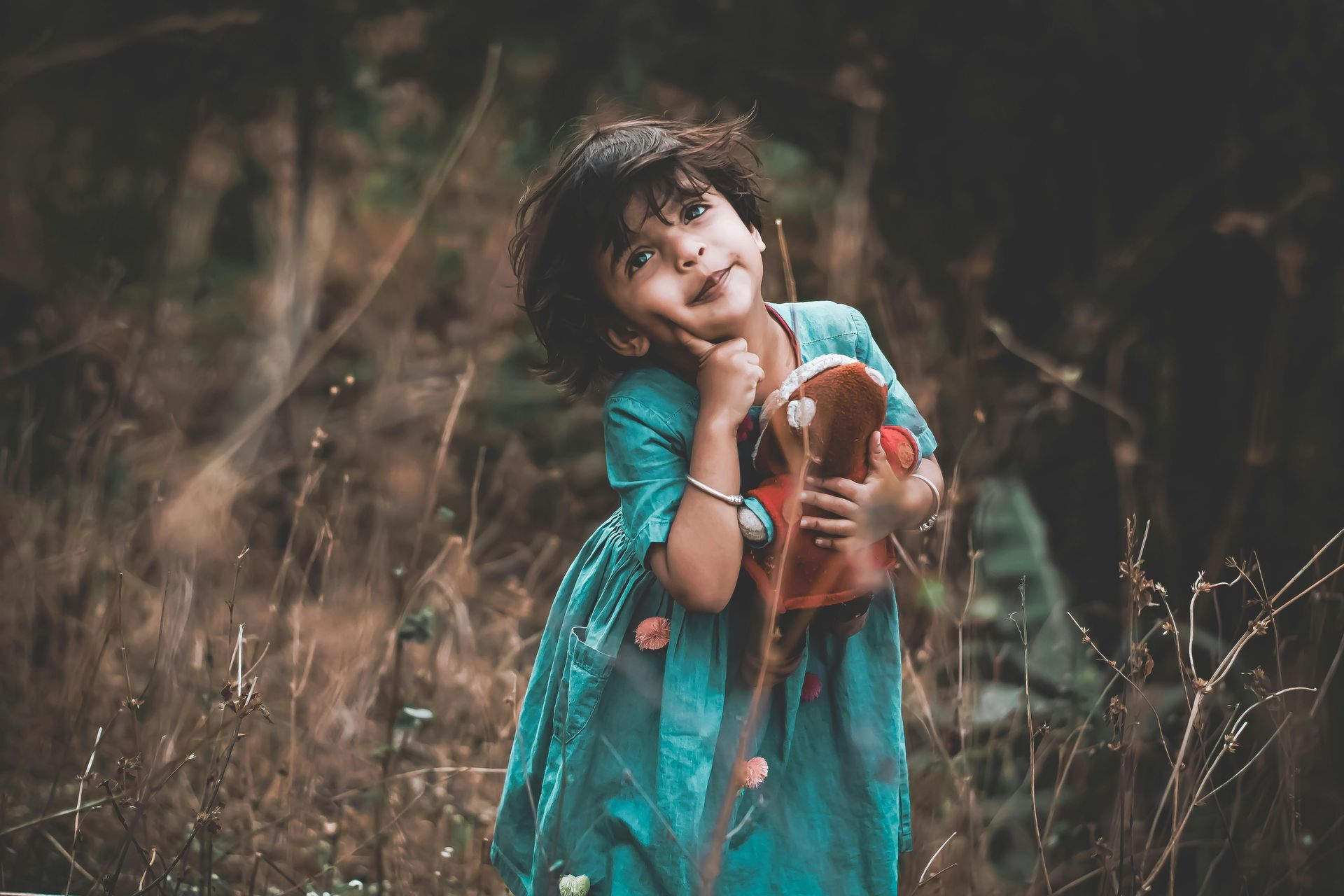 Young girl posing with stuffed toy looking in wonder and awe