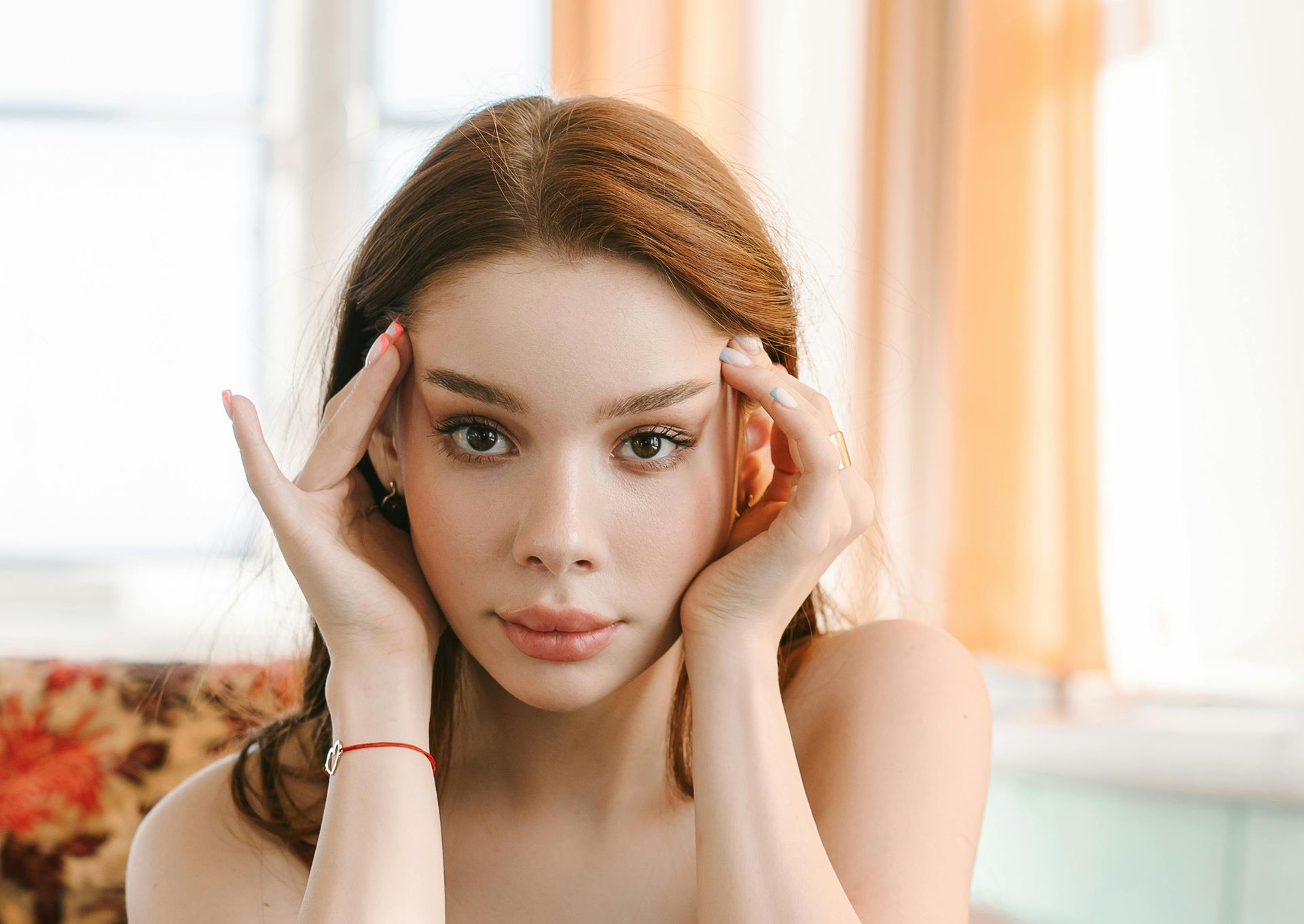 Woman holding temples and thinking
