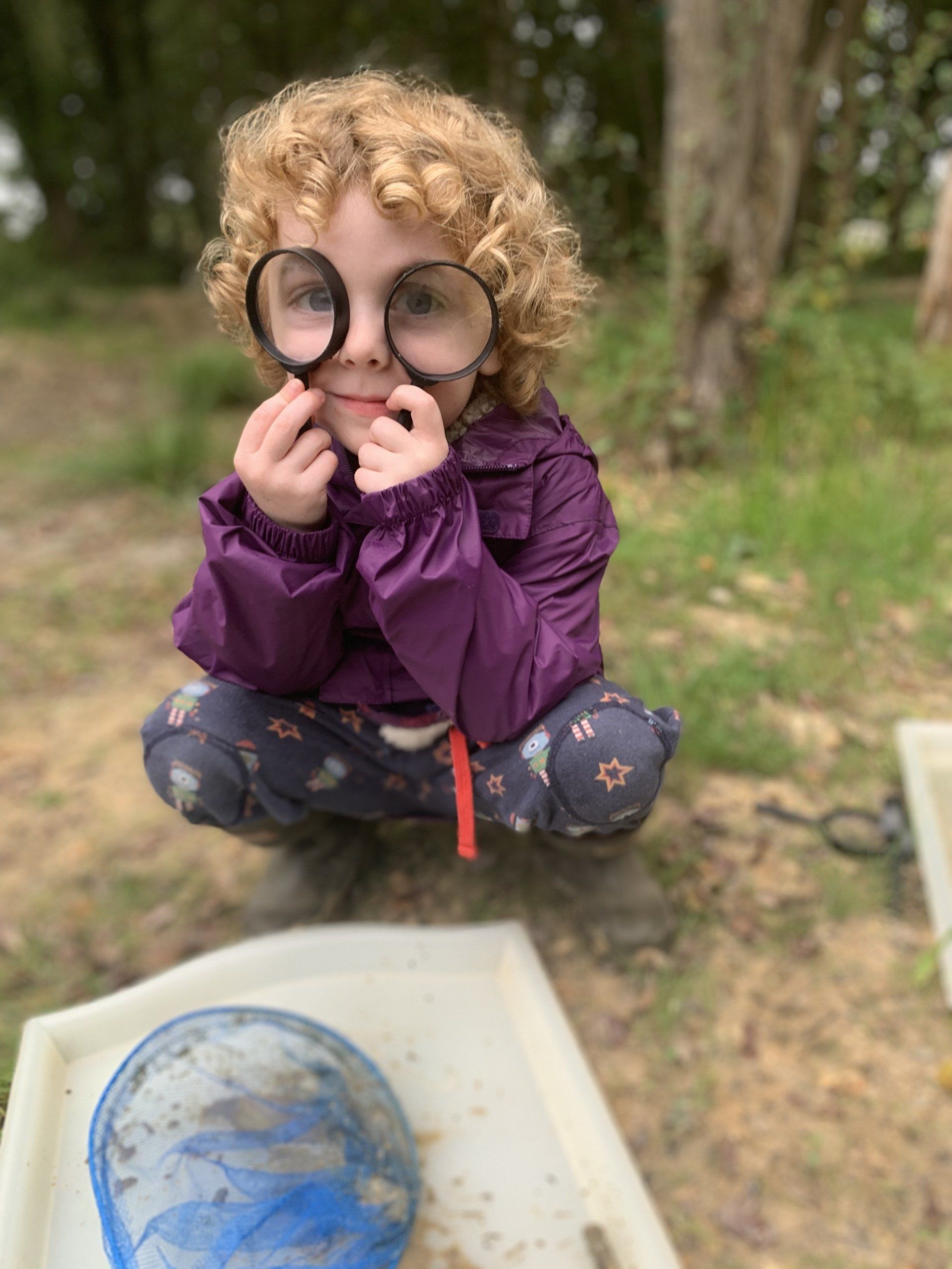 With two magnifying glasses for bug hunting